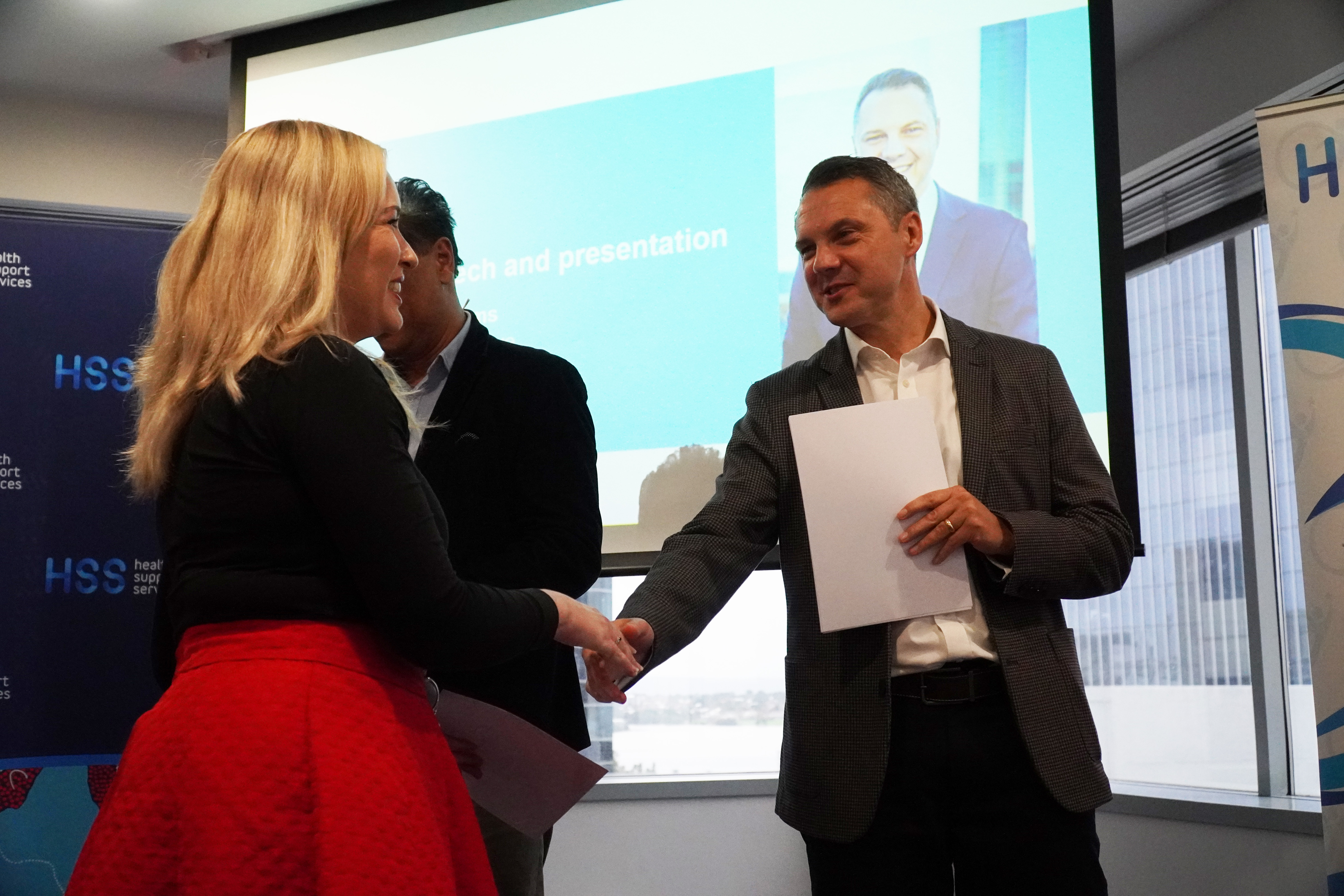 Chief Executive Robert Toms shaking hands with a graduate