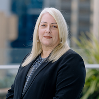 Blonde lady wearing navy blazer smiling at camera