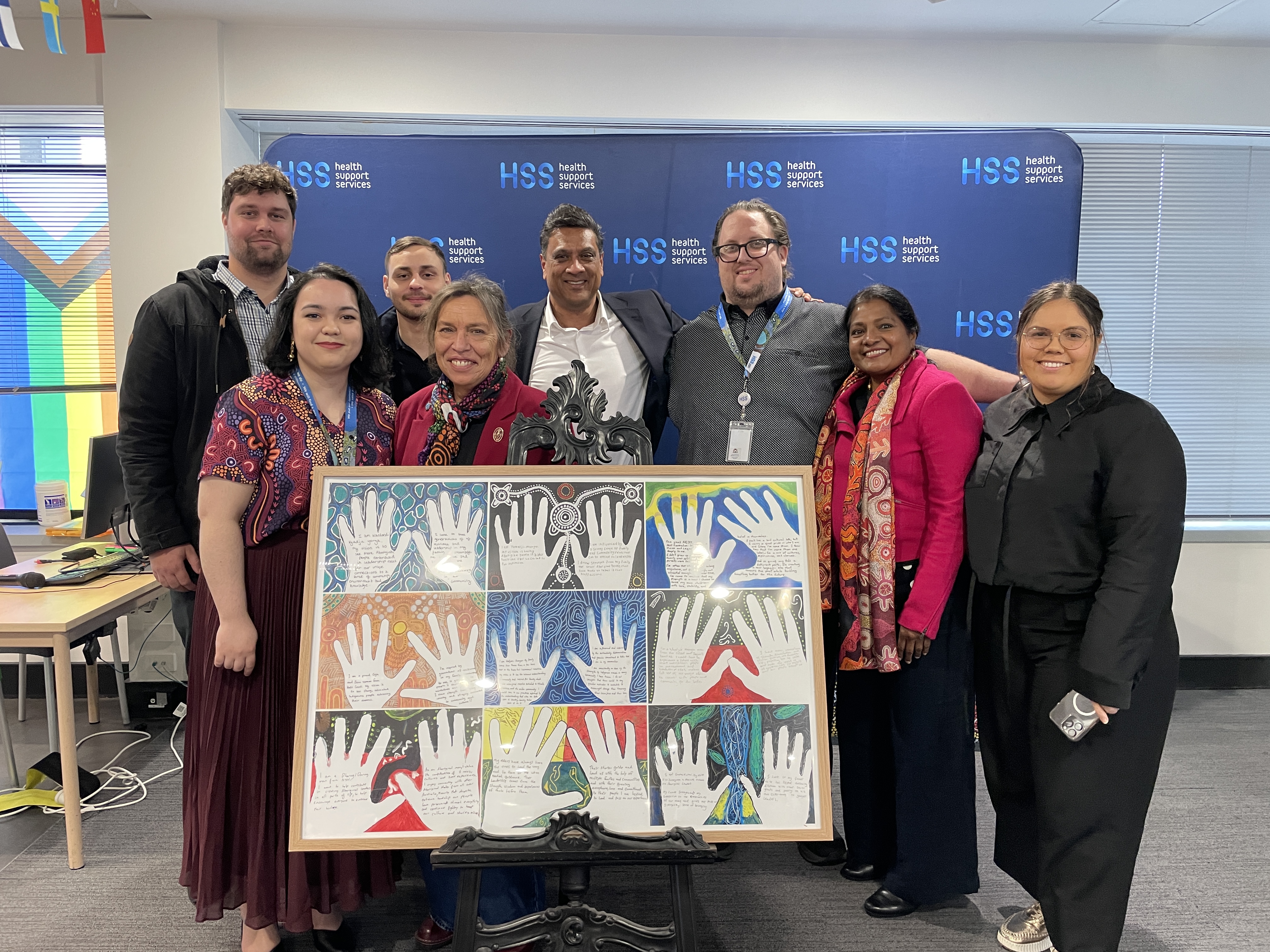 People standing with the Aboriginal artwork