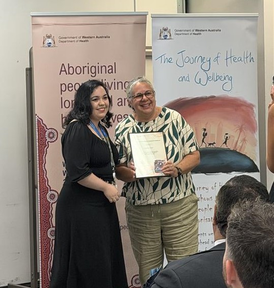 Two people shaking hands and holding a certificate